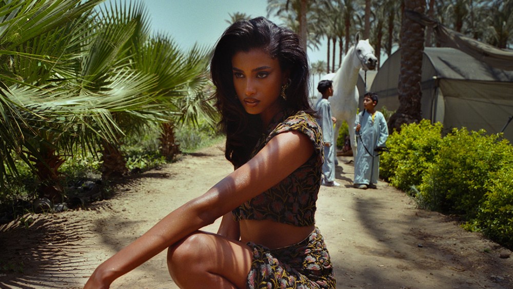 Model Imaan Hammam poses in Amina Muaddi shoes for Spring-Summer 2022 campaign