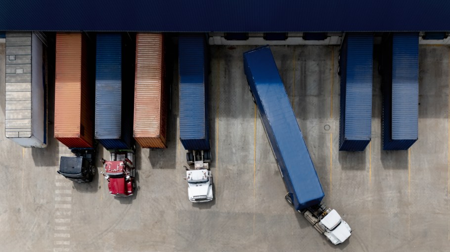 Aerial view of a truck leaving the loading dock at a distribution warehouse - freight transportation concepts